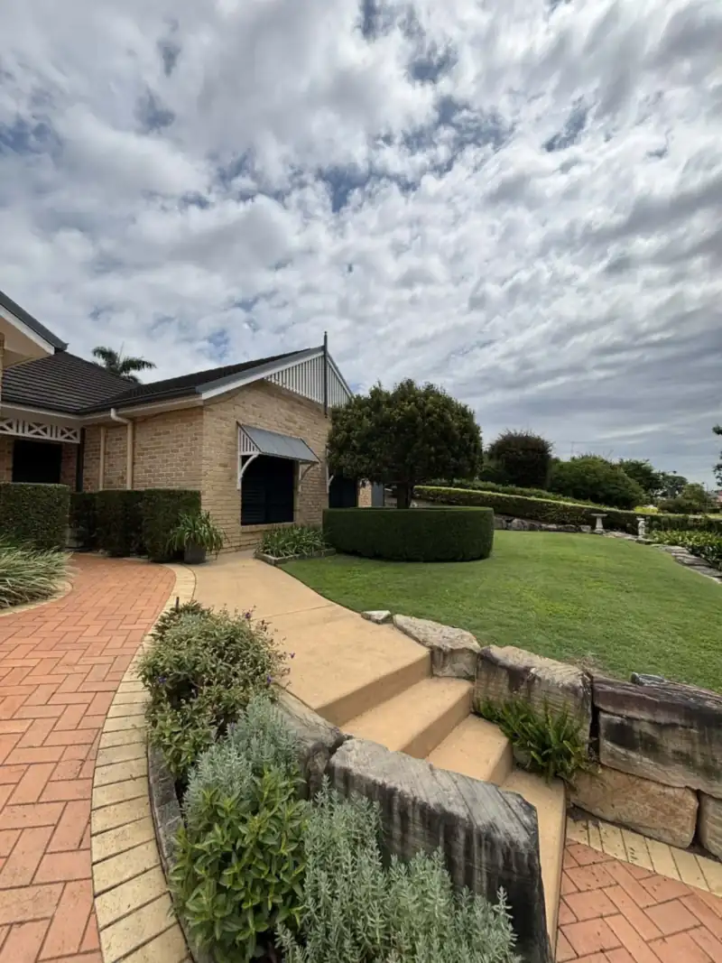 Garden maintenance Moreton Bay: tidy garden beds and pruned shrubs beside a home