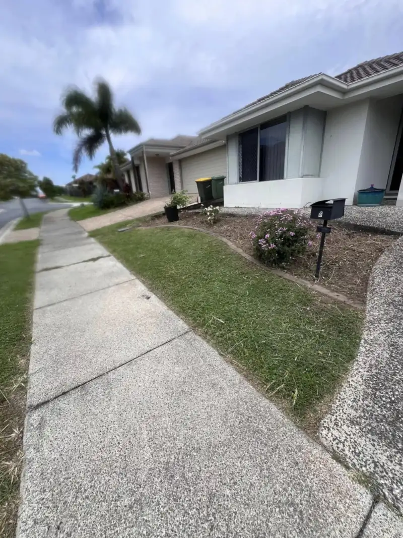 Neatly mown lawn and edged footpath in a quiet Moreton Bay street in the early morning mowing hours